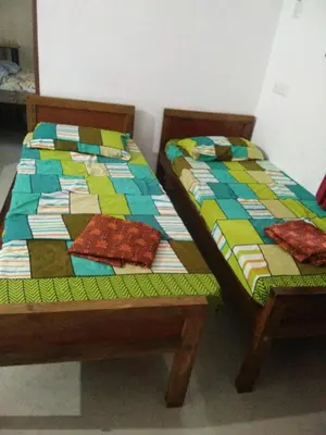 two beds sitting next to each other in a room at Nunu Homestay Guruvayoor in Guruvāyūr