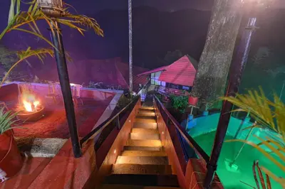 a set of stairs leading to a pool at night at Coorg Heritage Hill View By The Avyaan in Madikeri