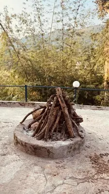 a pile of sticks sitting on top of a fire at Coorg Heritage Hill View By The Avyaan in Madikeri