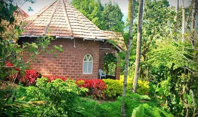 a small brick building with a window in a garden at Coorg Heritage Hill View By The Avyaan in Madikeri