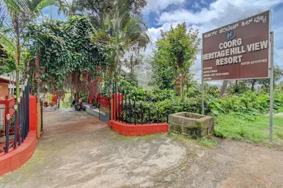 a sign in front of a garden with a fence at Coorg Heritage Hill View By The Avyaan in Madikeri