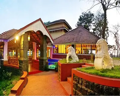 a house with two statues in front of it at The Porcupine Castle Resort in Madikeri