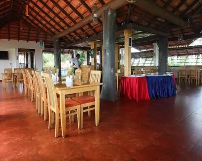 a dining room with a table and chairs and a tableablish at The Porcupine Castle Resort in Madikeri