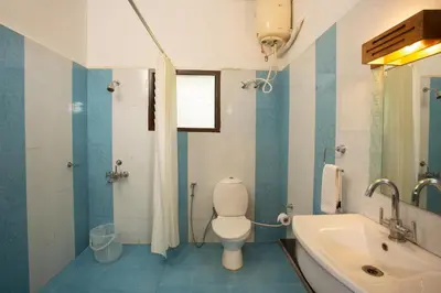 a bathroom with a white toilet and a sink at The Porcupine Castle Resort in Madikeri