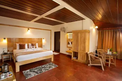 a bedroom with a bed and a table in a room at The Porcupine Castle Resort in Madikeri