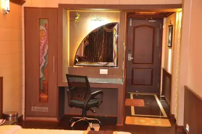 a room with a chair and a door with a window at Astoria Residency in Ooty