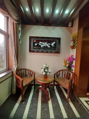 a room with two chairs and a table and a window at Astoria Residency in Ooty
