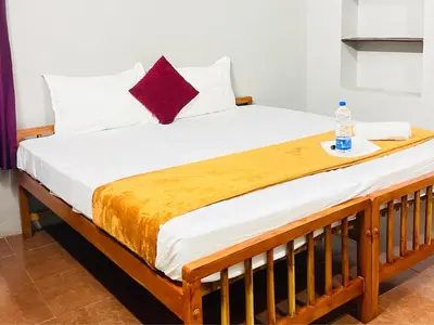a bed with two pillows and a bottle of water on it at GoNest O Zen in Kozhikode