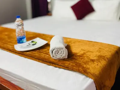 a bed with a towel and a bottle of water at GoNest O Zen in Kozhikode