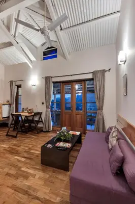 a living room with a purple couch and a table at Club Mahindra Danish Villa, Ooty in Ooty