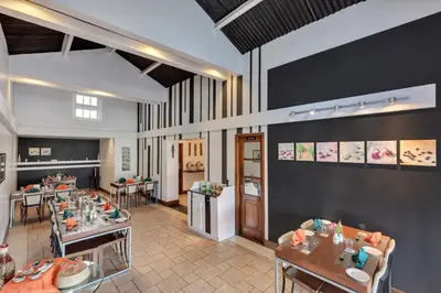 a restaurant with tables and chairs in a room at Club Mahindra Danish Villa, Ooty in Ooty