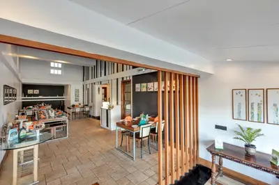 a living room with tables and a dining room at Club Mahindra Danish Villa, Ooty in Ooty