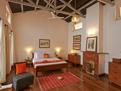 a bedroom with a bed and a chair in a room at Club Mahindra Danish Villa, Ooty in Ooty