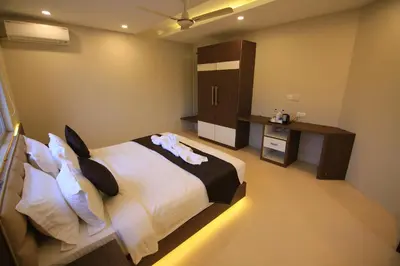 a bedroom with a large bed and a desk at Hotel Le Sapphire in Sultan Bathery