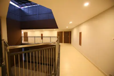 a staircase in a building with a large window at Hotel Le Sapphire in Sultan Bathery