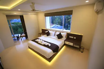 a bedroom with a large bed with a light on it at Hotel Le Sapphire in Sultan Bathery