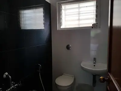 a bathroom with a toilet and a sink and a window at Comfort`s Pearl in Coimbatore