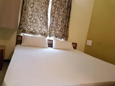 a bed with two pillows in a bedroom with a window at Comfort`s Pearl in Coimbatore