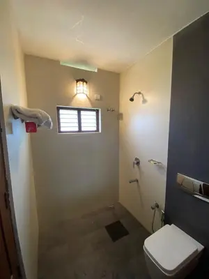 a bathroom with a toilet and a window at Pristine Hills in Meppādi
