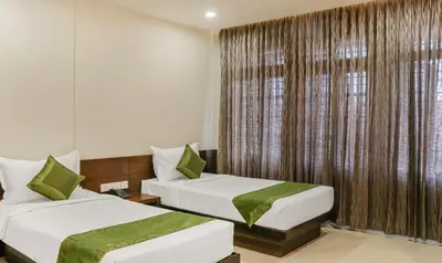 a hotel room with two beds and a window at Treebo Casino in Kozhikode