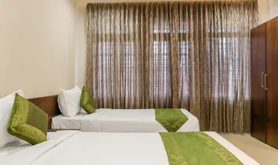 a hotel room with two beds and a window at Treebo Casino in Kozhikode