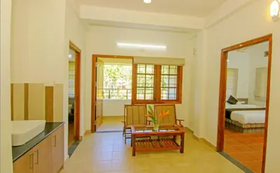 a living room with a kitchen and a bedroom at Dakshin Ghats in Tariyod