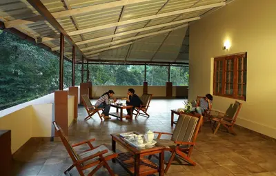 a group of people sitting at a table in a room at Dakshin Ghats in Tariyod