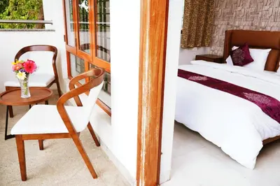 a bedroom with a bed and a chair and a table at UNNATHI SUITES in Mysore