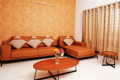 a living room with a couch and a table at UNNATHI SUITES in Mysore