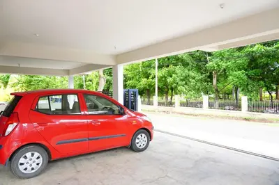 a small red car parked at a gas station at UNNATHI SUITES in Mysore