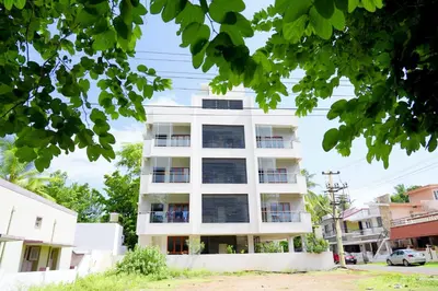 a white apartment building with black windows at UNNATHI SUITES in Mysore