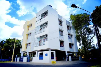 a white building with a street light in front of it at UNNATHI SUITES in Mysore