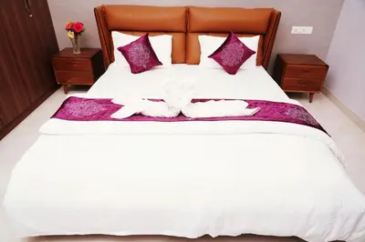 two dogs laying on a bed with purple pillows at UNNATHI SUITES in Mysore