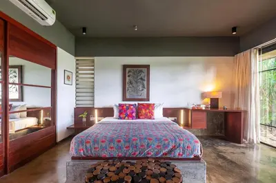 a bedroom with a large bed and a large window at StayVista at Toya Toya River View in Kozhikode