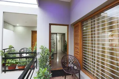 a balcony with a table and chairs and plants at Like My Apartment in Mysore