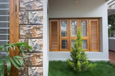 a window with wooden shutters on a house at Like My Apartment in Mysore