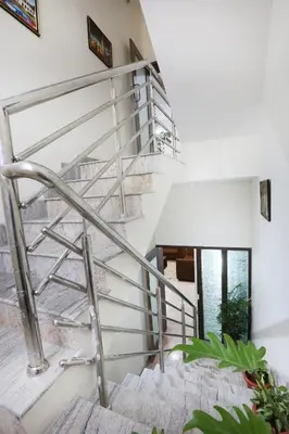 a spiral staircase in a house with plants at Like My Apartment in Mysore