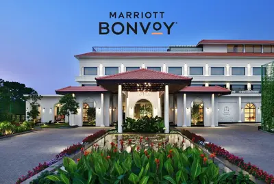 a large white building with flowers in front of it at Port Muziris, A Tribute Portfolio Hotel by Marriott, Kochi Airport in Nedumbassery