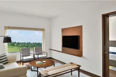 a living room with a couch and a tv at Port Muziris, A Tribute Portfolio Hotel by Marriott, Kochi Airport in Nedumbassery