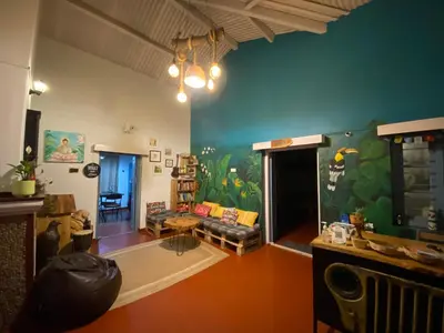 a living room with a couch and a colorful wall at The Birdhouse Backpackers Hostel in Coonoor
