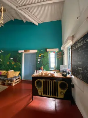 a room with a desk with a chalkboard on the wall at The Birdhouse Backpackers Hostel in Coonoor