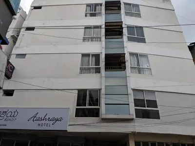 a tall white building with a sign in front of it at Aashraya in Mysore