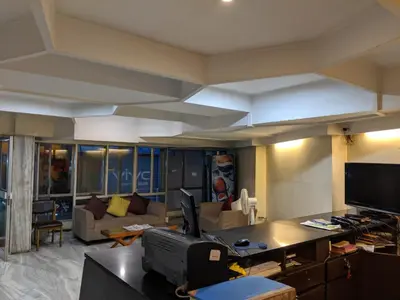 a living room with a couch and a table with a tv at Aashraya in Mysore