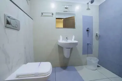 a white bathroom with a toilet and a sink at Bhavanam Regency Guruvayoor in Guruvāyūr