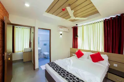a bedroom with a bed with red pillows at Bhavanam Regency Guruvayoor in Guruvāyūr