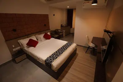 a bedroom with a bed with red pillows on it at Bhavanam Regency Guruvayoor in Guruvāyūr