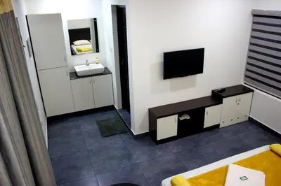 a living room with a television and a bathroom at Vintage Garden Resort in Sultan Bathery
