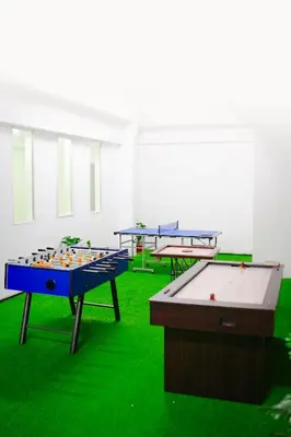 two ping pong tables in a room with green grass at Athirappilly Rainland Resort in Athirappilly