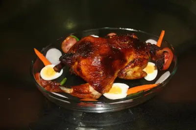 a plate of food with a chicken on top of vegetables at Whistling Woods Farm Stay in Kushālnagar