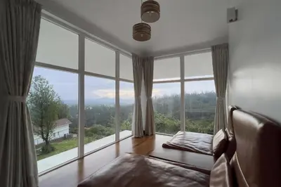 a living room with large windows and a couch at StayVista at The Lilly Ooty with Breakfast in Ooty